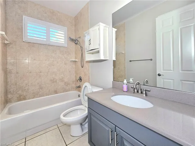 Bathroom featuring bathtub / shower combination, tile patterned floors, toilet, and vanity