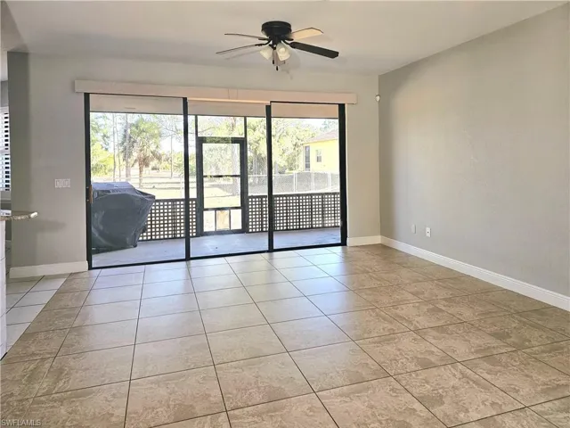 Empty room featuring a ceiling fan, baseboards, and tile patterned flooring
