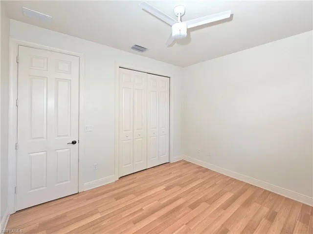 Unfurnished bedroom featuring light wood-style floors, baseboards, a closet, and a ceiling fan