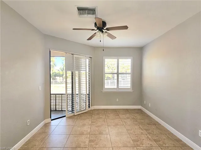 Spare room featuring ceiling fan, baseboards, and light tile patterned floors