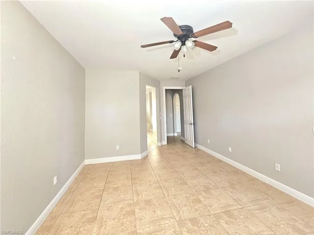 Unfurnished room with baseboards and a ceiling fan