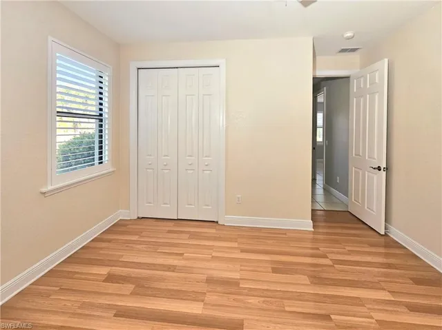 Unfurnished bedroom with light wood-style floors, baseboards, and a closet