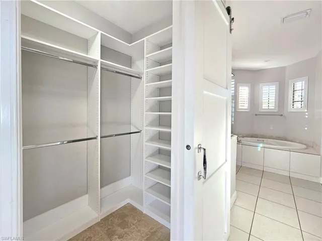 Spacious closet with light tile patterned floors