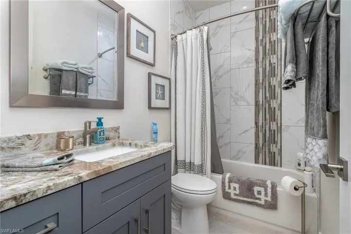 Full bathroom featuring shower / bath combo, vanity, and toilet