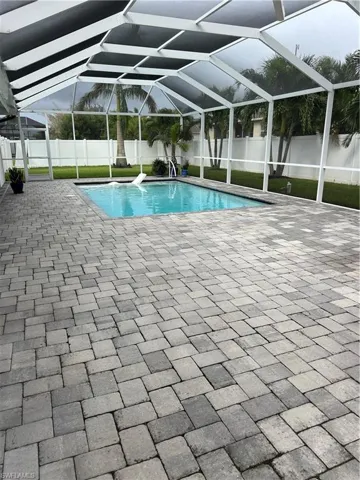 View of swimming pool with a patio and a lanai