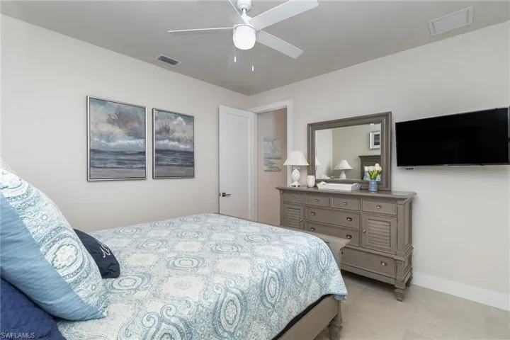 Bedroom with ceiling fan and light tile patterned flooring