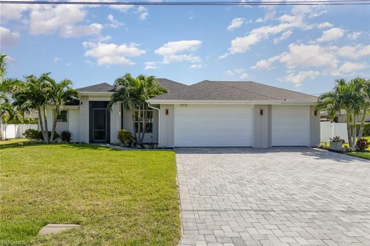 Ranch-style house featuring a front yard and a 3 car garage