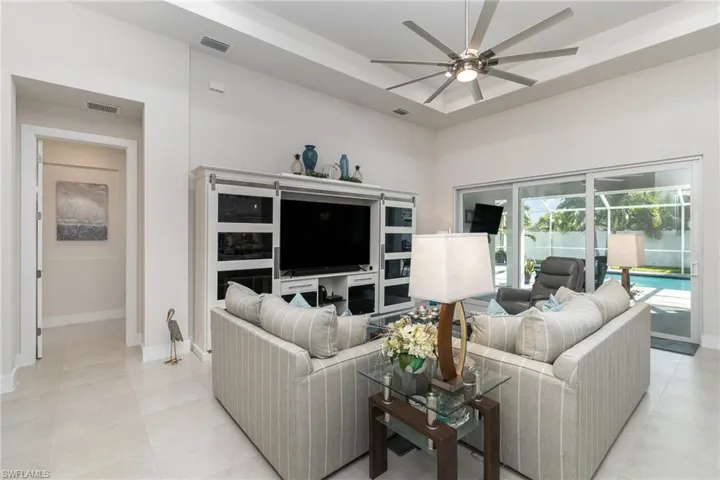 Living room with ceiling fan and light tile patterned floors