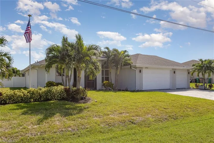 View of front of home with a garage and a front lawn