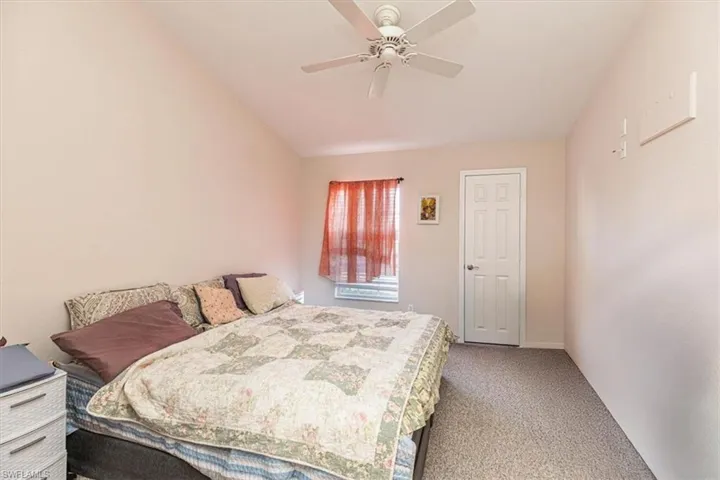 Bedroom with light colored carpet and a ceiling fan