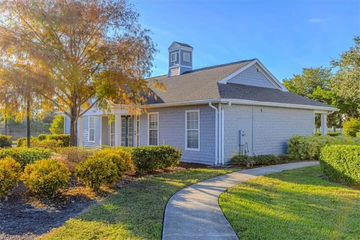 View of side of property featuring a lawn and a shingled roof