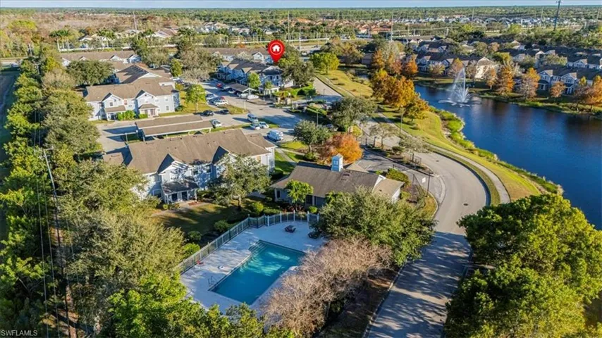 Aerial view of property and surrounding area with a nearby body of water and nearby suburban area