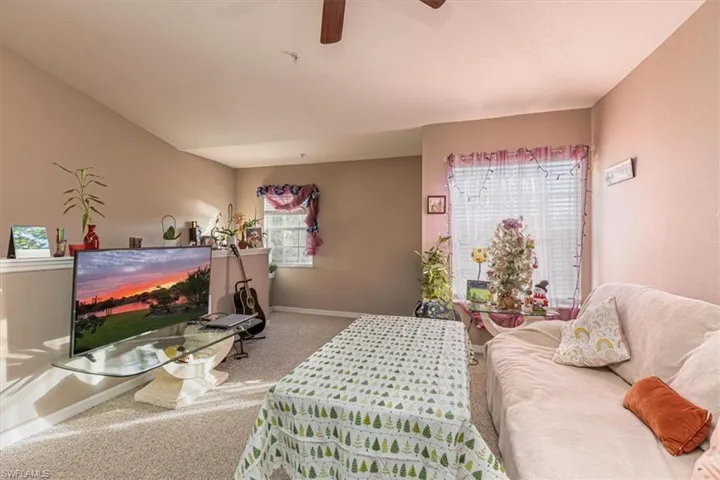 Living area with carpet and a ceiling fan