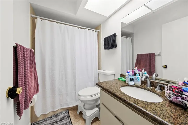 Bathroom with tile patterned flooring, vanity, toilet, and walk in shower