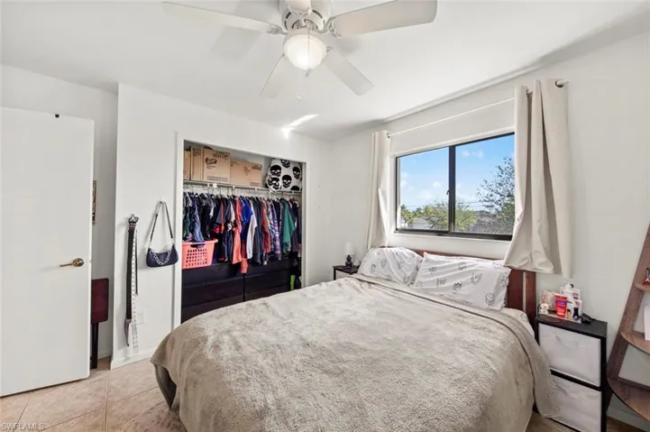 Tiled bedroom with a closet and ceiling fan