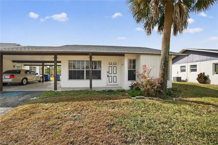 Ranch-style home featuring an attached carport & large driveway
