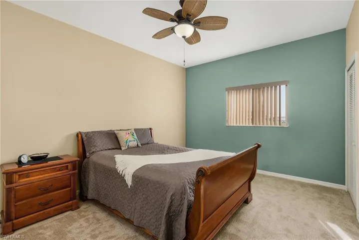 Carpeted bedroom with a closet and ceiling fan