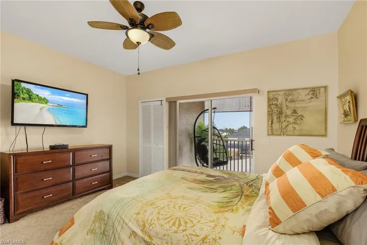Bedroom featuring light carpet, access to outside, a closet, and ceiling fan