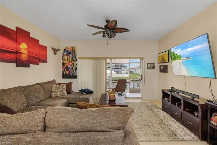 Living room featuring light tile patterned floors and ceiling fan