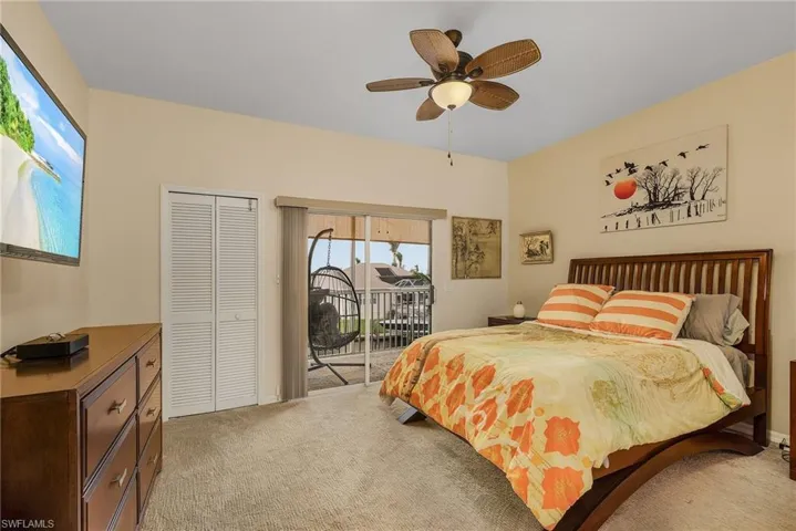 Carpeted bedroom with a closet, access to exterior, and ceiling fan