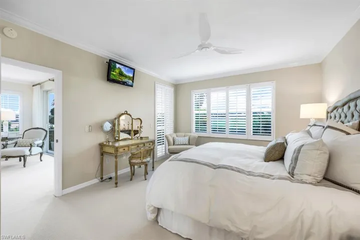 Carpeted bedroom featuring ornamental molding and ceiling fan