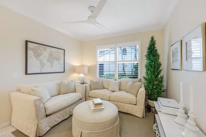 Living room featuring ceiling fan and ornamental molding