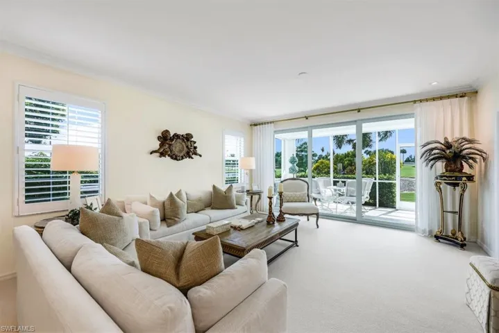 Living room with crown molding, carpet, and a wealth of natural light