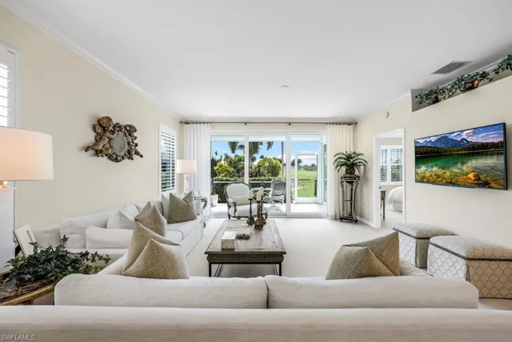 Living room with ornamental molding and light colored carpet