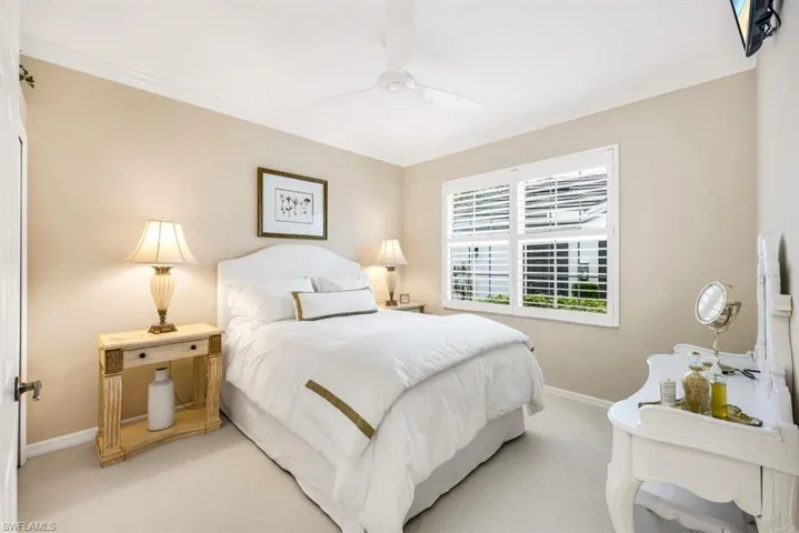Bedroom featuring ceiling fan, light colored carpet, and ornamental molding
