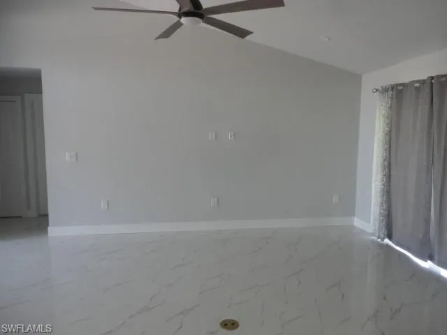 Unfurnished room with ceiling fan, baseboards, and marble finish flooring