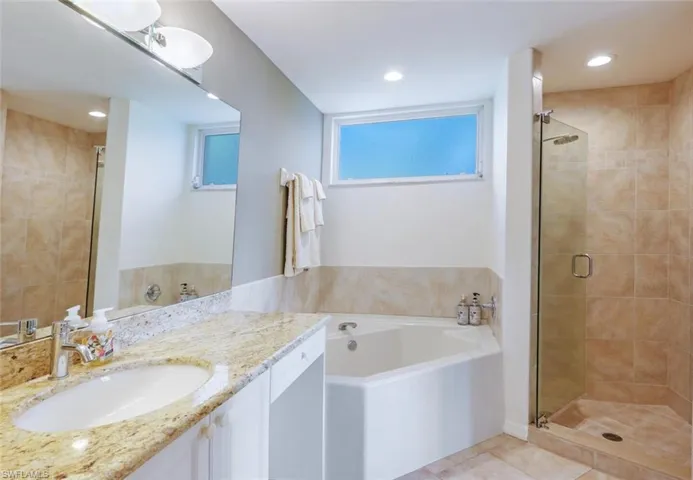 Bathroom featuring vanity, a shower stall, a bath, recessed lighting, and light tile patterned floors