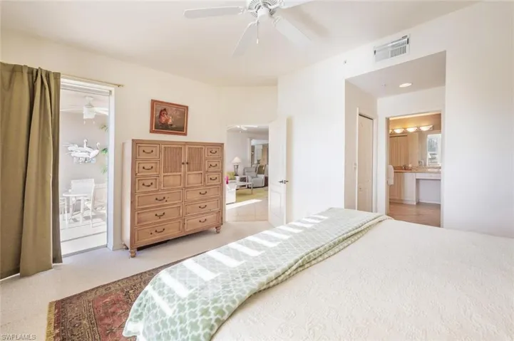 Bedroom with connected bathroom, ceiling fan, and light carpet