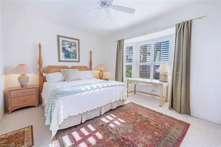 Carpeted bedroom featuring a ceiling fan and baseboards