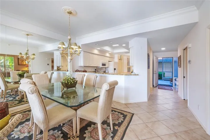 Dining room featuring a chandelier, light tile patterned floors, crown molding, and recessed lighting