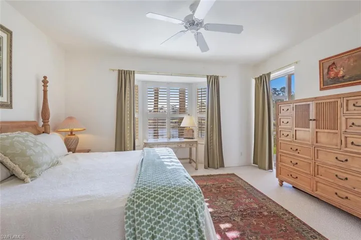Bedroom with ceiling fan and light colored carpet