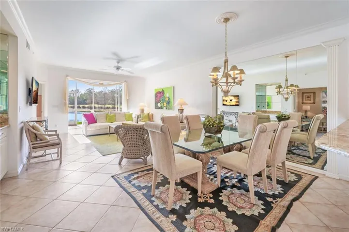 Dining area featuring light tile patterned floors, ceiling fan, a chandelier, and crown molding