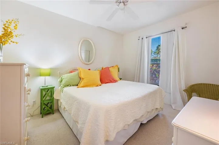 Carpeted bedroom featuring a ceiling fan