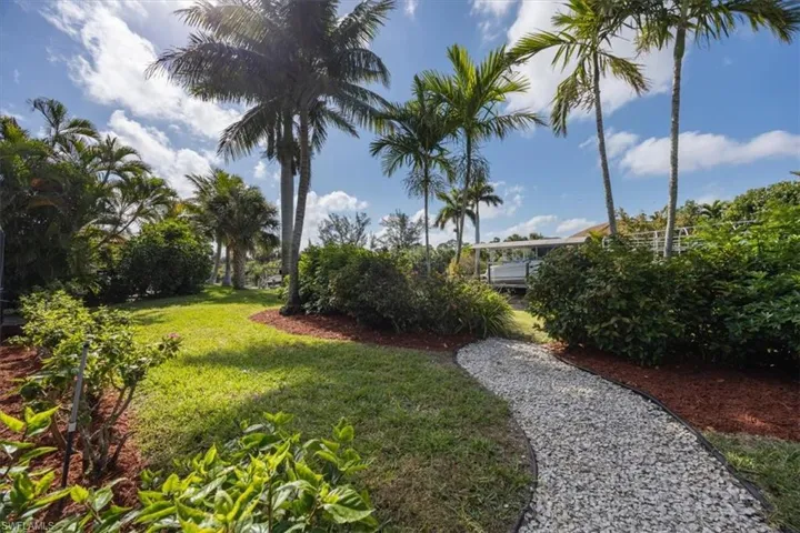 View of back yard, path leading to canal and landscaping.