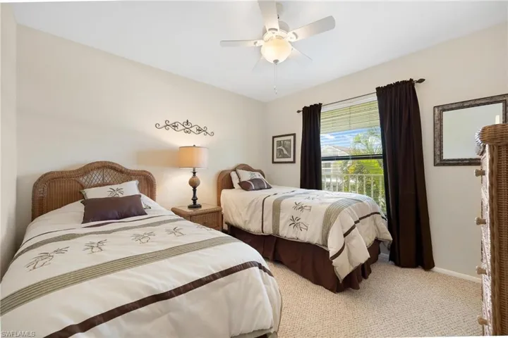 Carpeted bedroom featuring ceiling fan and baseboards
