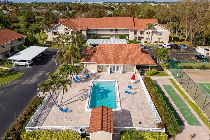 Drone / aerial view of a pool area and a tree filled landscape