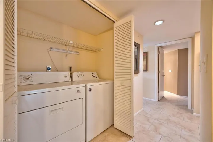 Laundry room featuring independent washer and dryer, recessed lighting, and light tile patterned flooring