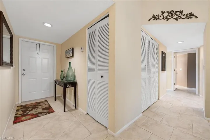 Hallway featuring recessed lighting and light tile patterned floors