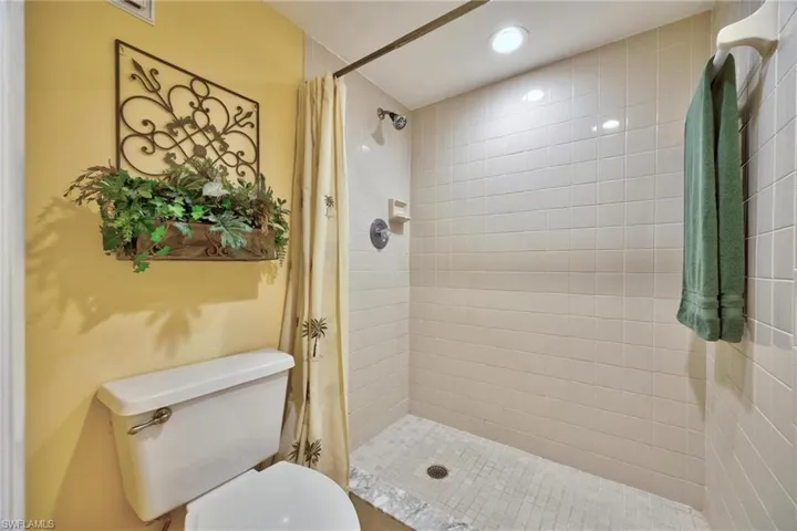 Bathroom with a shower stall and toilet