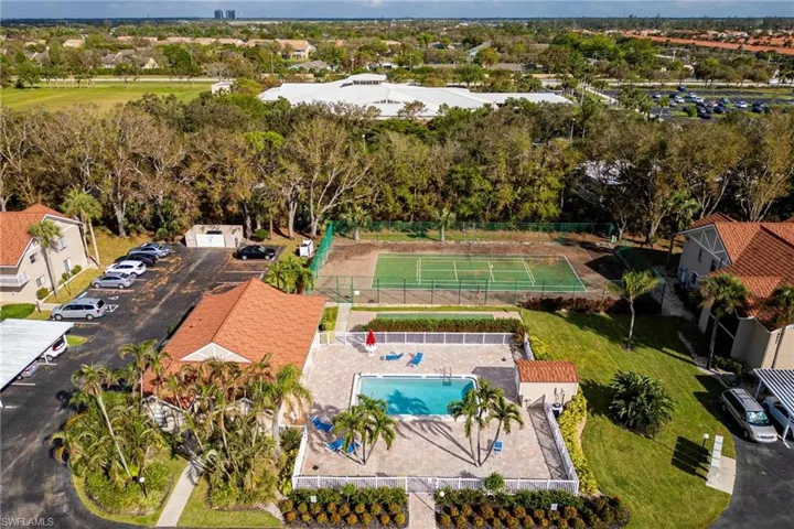 Drone / aerial view of a pool and a tree filled landscape
