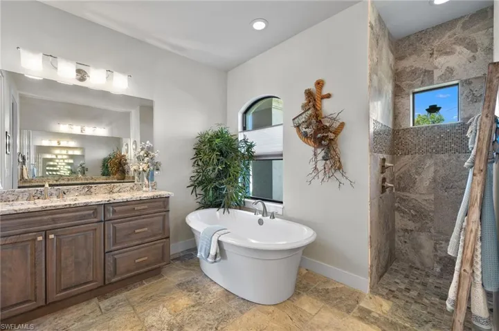 Bathroom featuring tile flooring, vanity, and independent shower and bath
