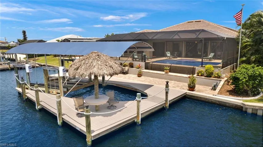 View of dock featuring glass enclosure and a water view
