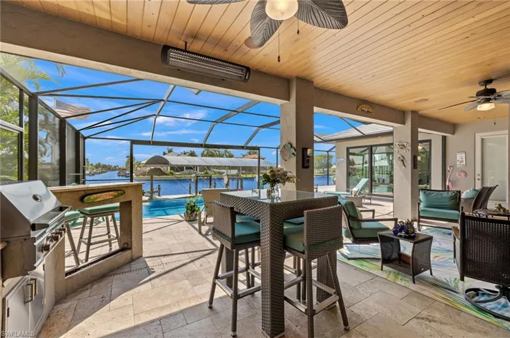 Sunroom with a wealth of natural light, a water view, ceiling fan, and wood ceiling