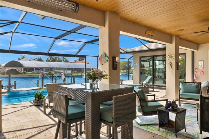 View of patio with ceiling fan, a lanai, and a water view