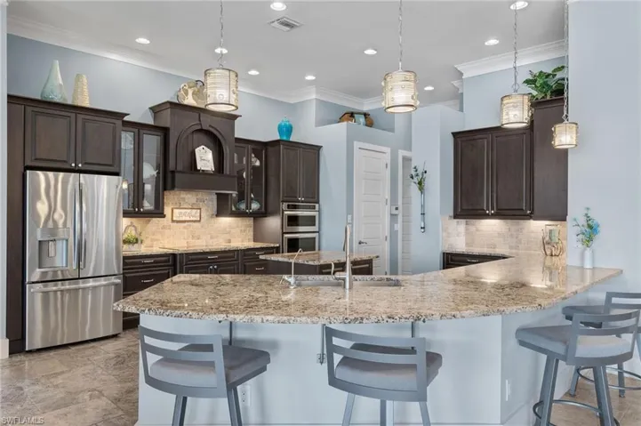 Kitchen featuring tasteful backsplash, pendant lighting, and stainless steel appliances