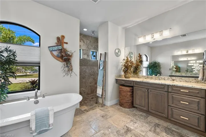 Bathroom featuring tile floors, vanity, and a bathtub